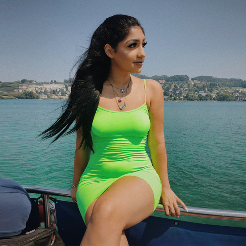 a woman in a neon green swimsuit sitting on a boat