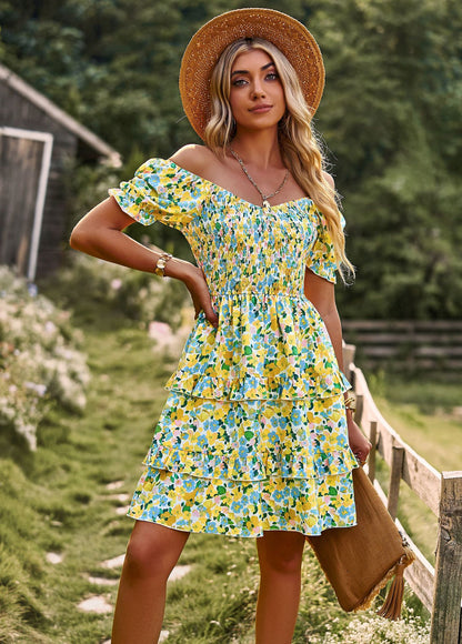 a woman in a yellow floral dress and straw hat